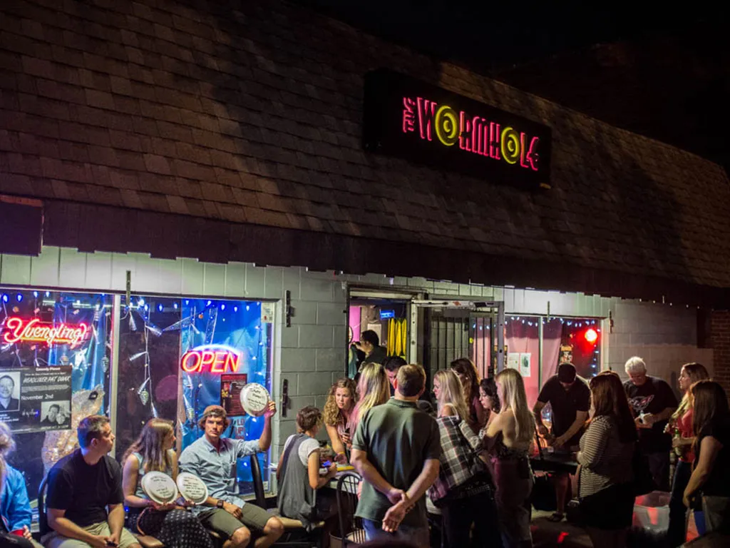 The Wormhole Savannah exterior at night with crowd outside